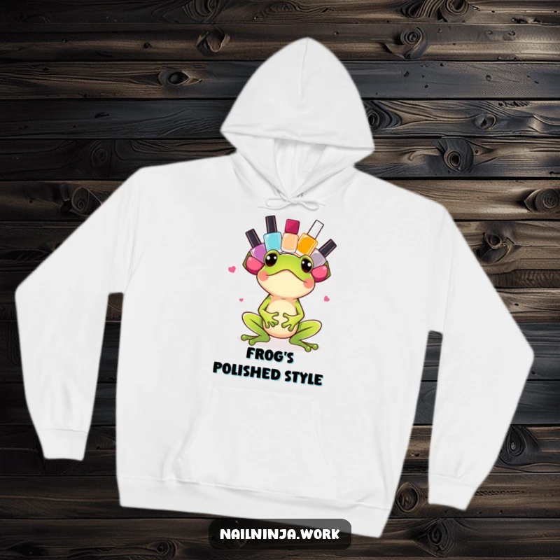 Funny excited green frog balancing nail polish bottles on its head, on a cozy hoodie.